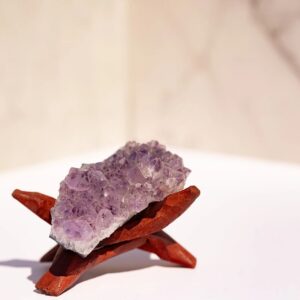 Natural Amethyst Cluster featuring numerous lavender and purple crystal points across an elongated unpolished mineral base.